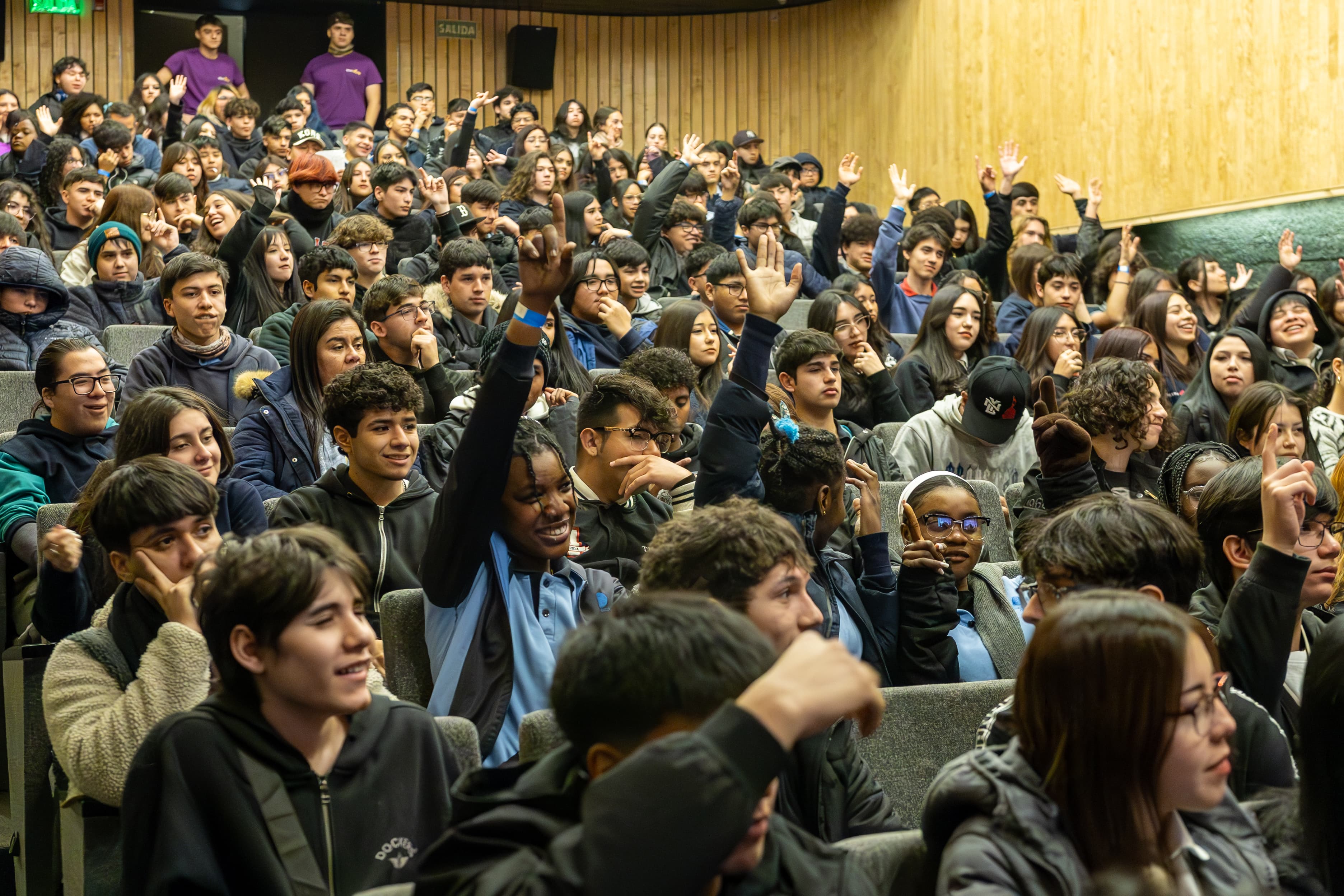 Jóvenes participando y levantando la mano en un panel en el Congreso HiveYoung